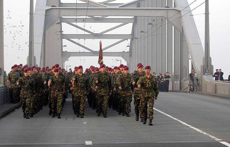 Soldiers from The 2nd Battalion The Parachute Regiment line the bridge in Arnhem (John Frost Bridge) and have a small memorial ceremony. Today was the 65th anniversary commemorations of Operation Market Garden, one of the most notable military operations of World War 2, which was held at Arnhem in the Netherlands. At 7am 2 PARA marched onto John Frost Bridge, the famous ' Bridge Too Far' to hold a memorial service. It is named after the then Commanding Officer of 2 PARA. Following the service there was the annual service at Oosterbeek cemetery attended by veterans and their families. This year Secretary of State for Defence Bob Ainsworth laid a wreath at the memorial. At the end of the service around 700 local Dutch children laid flowers on each of the graves at the cemetery.
